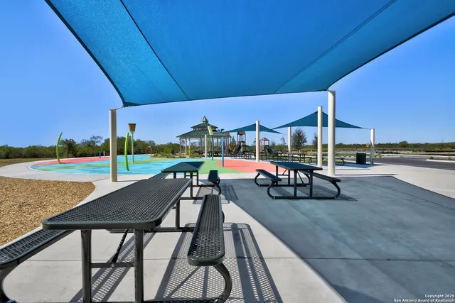 a view of a patio with a table and chairs under an umbrella