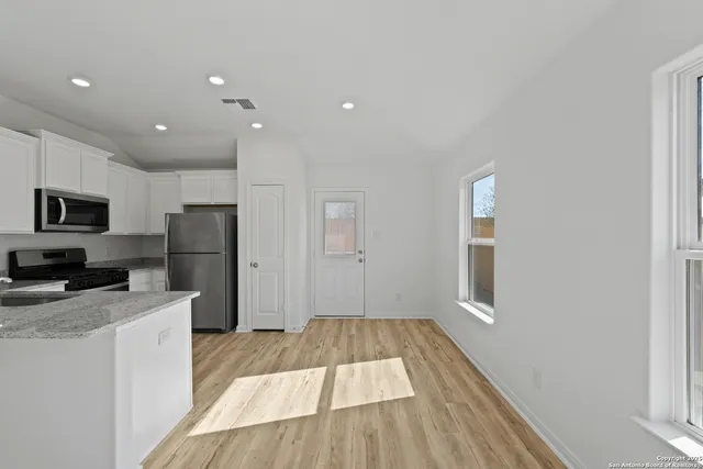 a kitchen with a refrigerator and a stove top oven