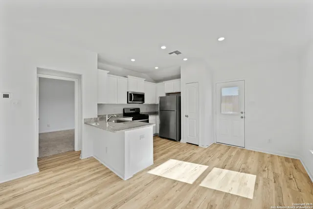 a kitchen with stainless steel appliances a refrigerator and a stove top oven