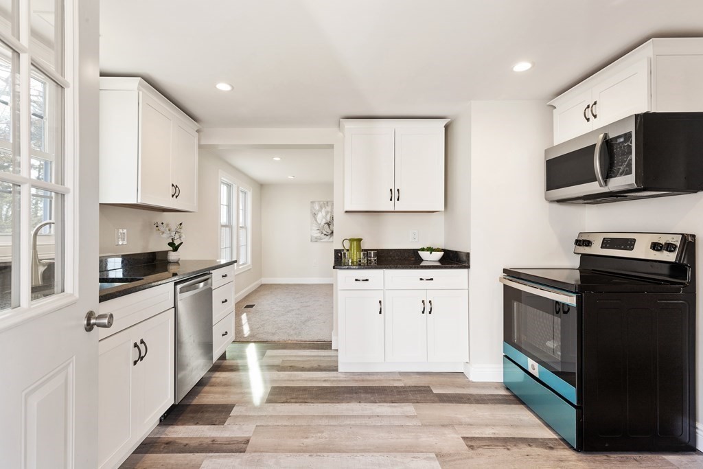 2 Pine Grove Road Westford, MA 01886 - Photo 3 of 27 a kitchen with stainless steel appliances granite countertop a stove top oven a sink dishwasher and a refrigerator with wooden floor