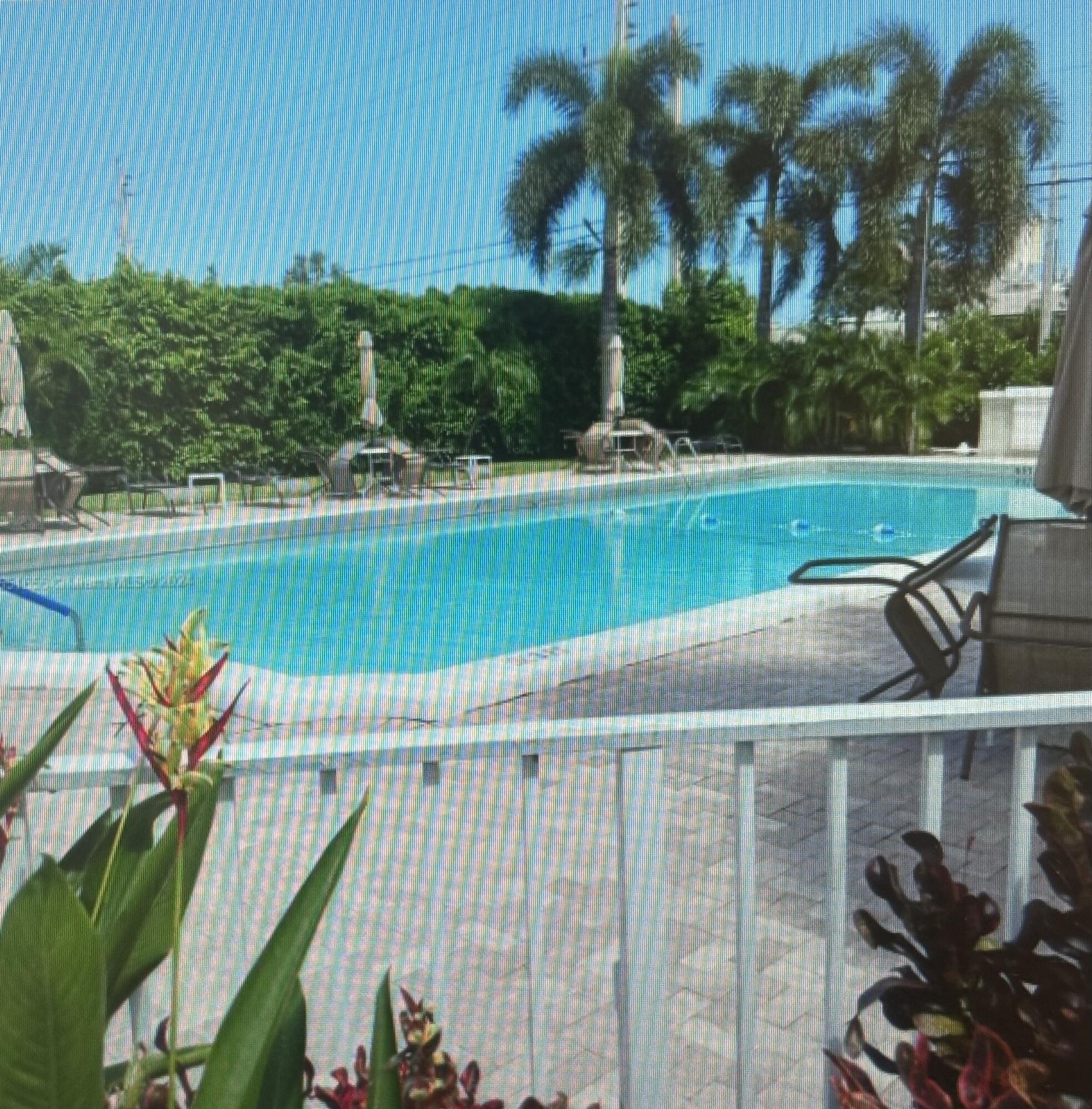 200 Main Boulevard, Unit 2D Boynton Beach, FL 33435 - Photo 2 of 26 a view of a swimming pool with a patio and a yard