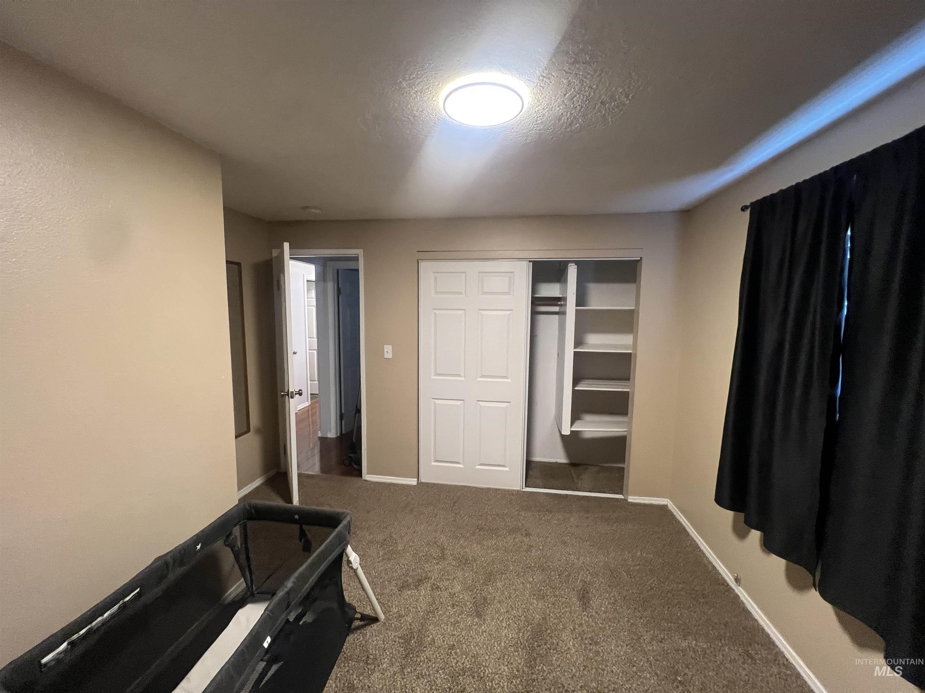 908 13th Street Kamiah, ID 83536 - Photo 11 of 12 Bedroom with carpet, a textured ceiling, and a closet