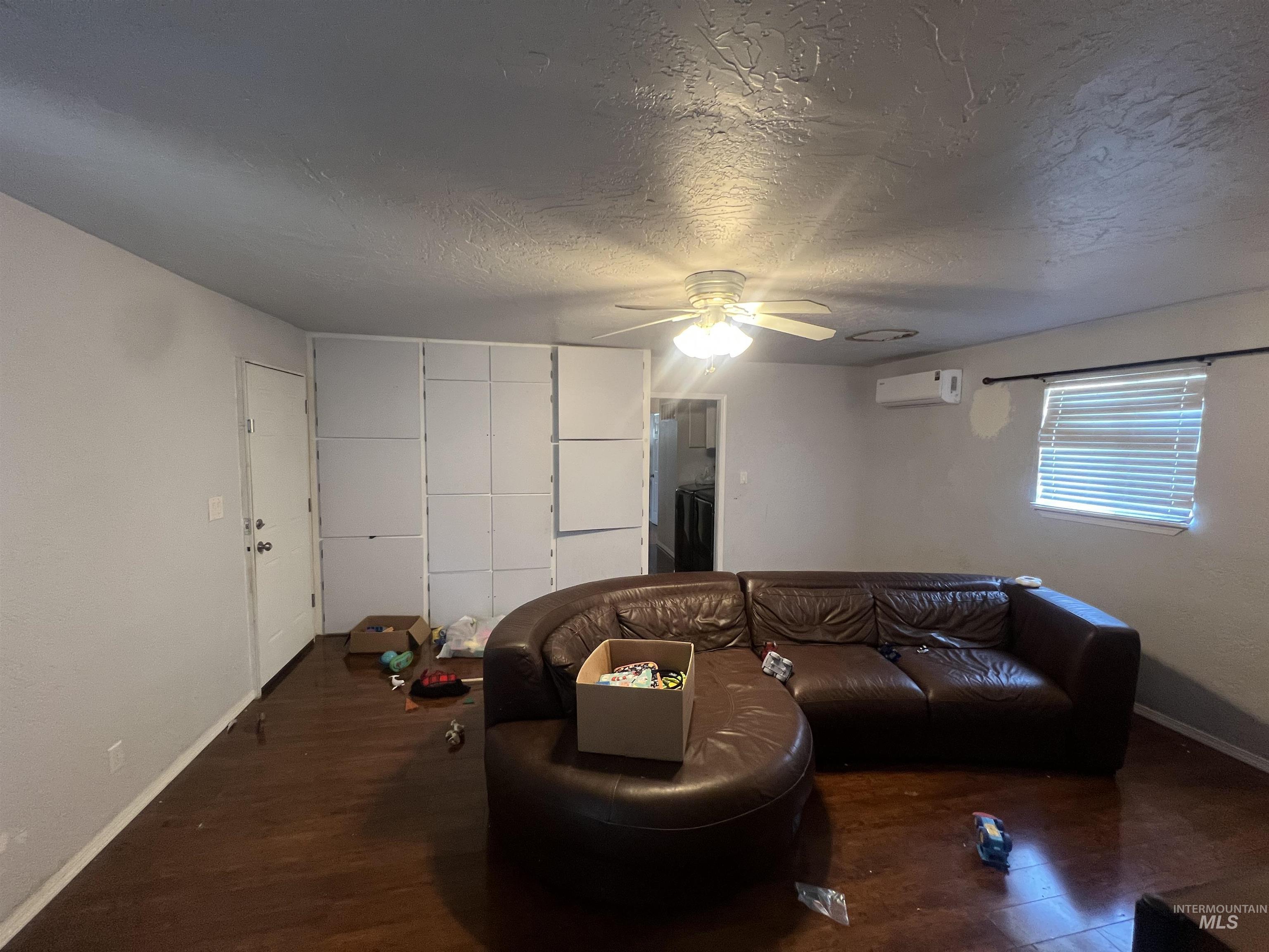 908 13th Street Kamiah, ID 83536 - Photo 5 of 12 Living area with a textured ceiling, wood finished floors, and a ceiling fan