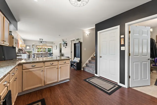 a kitchen with stainless steel appliances granite countertop a refrigerator a sink and white cabinets