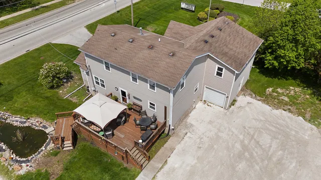an aerial view of a house with a yard and large trees