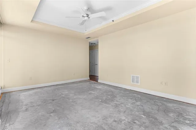 an empty room with a ceiling fan and carpet