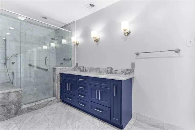 a bathroom with a granite countertop sink mirror and shower