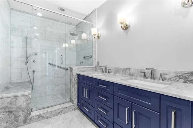 a bathroom with a granite countertop sink mirror and shower