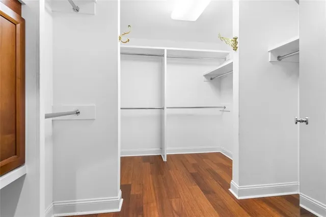 a view of walk in closet with wooden floor