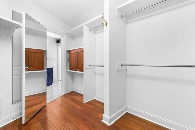 a view of walk in closet with wooden floor
