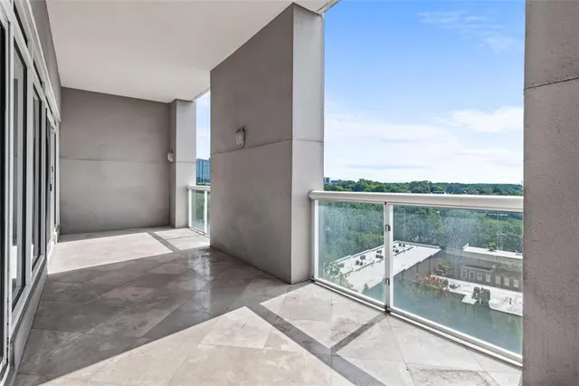 a view of a balcony with a floor to ceiling window and an outdoor kitchen
