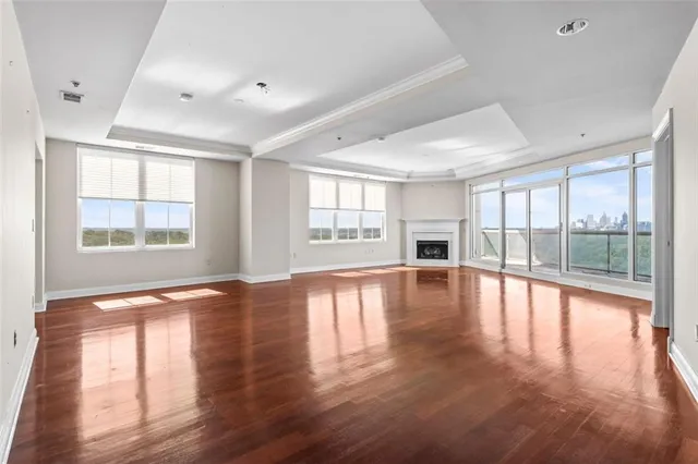 a view of empty room with wooden floor and fireplace