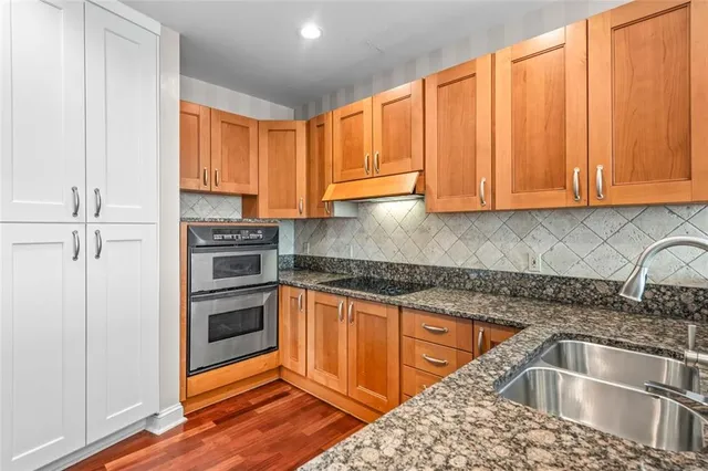 a kitchen with stainless steel appliances granite countertop a sink stove and refrigerator