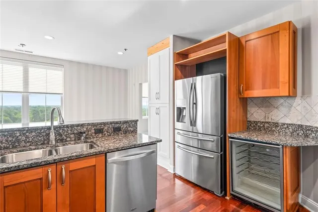 a kitchen with stainless steel appliances granite countertop a refrigerator and a sink