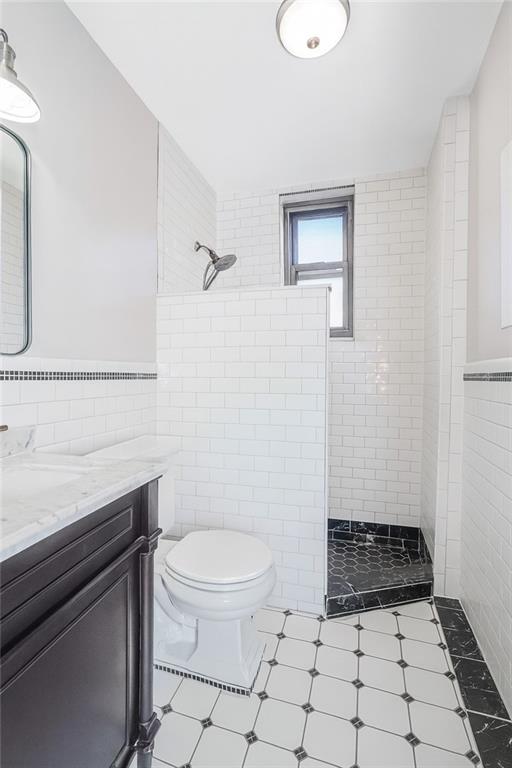 255 79th Street, Unit E2 Brooklyn, NY 11209 - Photo 11 of 14 a bathroom with a toilet a sink and a mirror