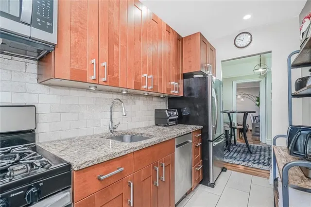 a kitchen with stainless steel appliances granite countertop a stove a sink and a microwave