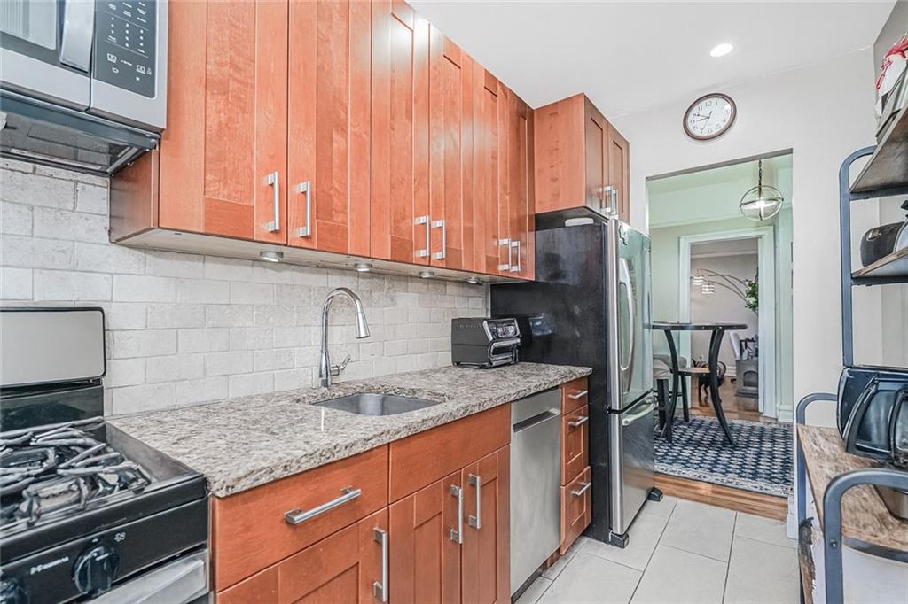 255 79th Street, Unit E2 Brooklyn, NY 11209 - Photo 8 of 14 a kitchen with stainless steel appliances granite countertop a stove a sink and a microwave