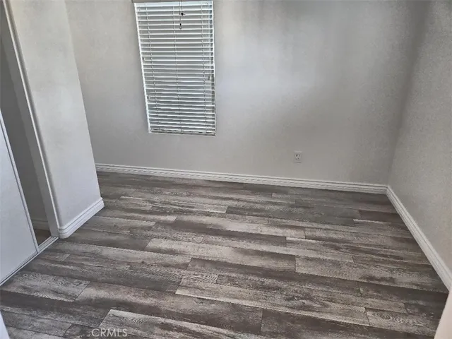 a view of a room with wooden floor and a window