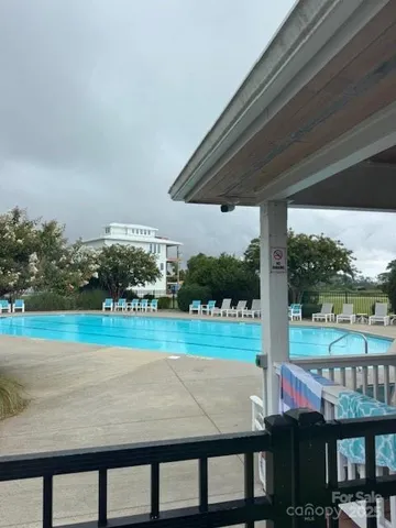 a view of swimming pool with a table and chairs under an umbrella