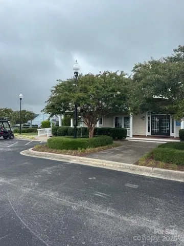 a view of a house with a yard and palm trees