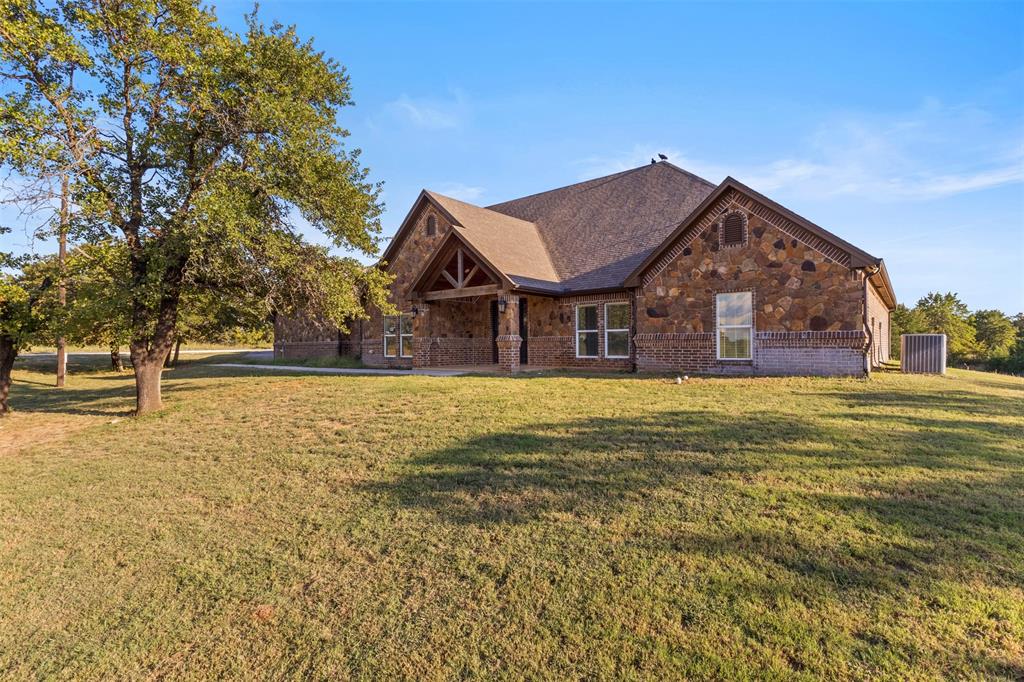 Ranch-style home featuring stone siding, a front yard, and brick siding