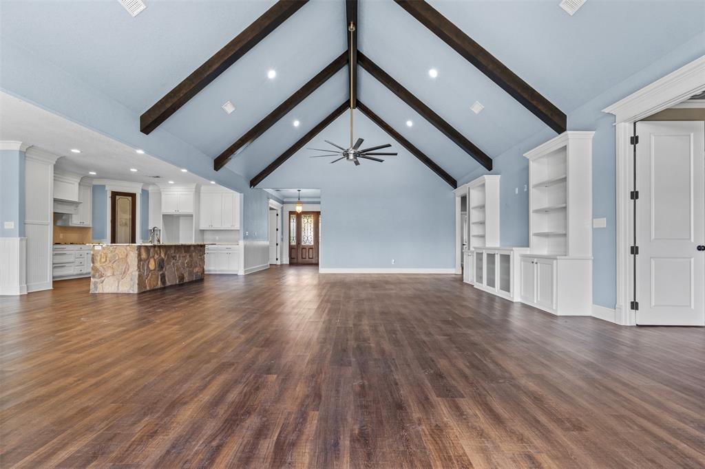 910 County Road 1111 Decatur, TX 76234 - Photo 13 of 40 Unfurnished living room featuring beamed ceiling, dark wood finished floors, high vaulted ceiling, recessed lighting, and built in shelves