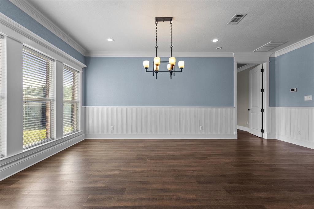 910 County Road 1111 Decatur, TX 76234 - Photo 16 of 40 Unfurnished dining area with crown molding, dark wood-style floors, recessed lighting, a chandelier, and wainscoting