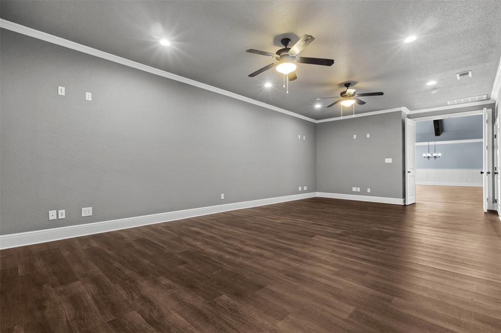 910 County Road 1111 Decatur, TX 76234 - Photo 18 of 40 Empty room with ornamental molding, dark wood-style flooring, recessed lighting, and a chandelier