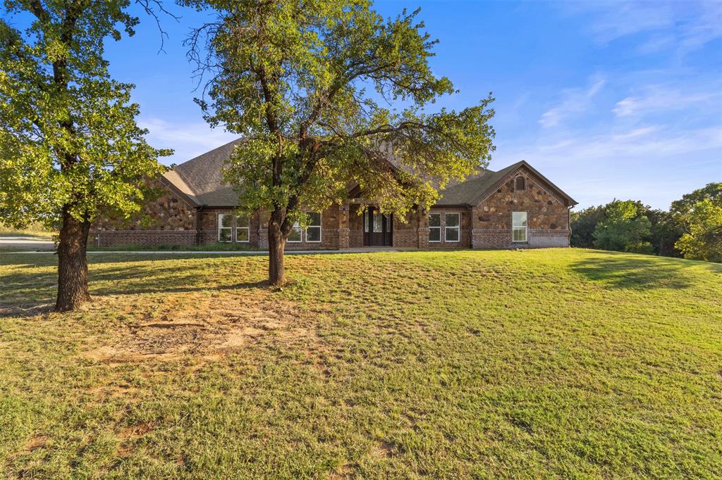 910 County Road 1111 Decatur, TX 76234 - Photo 2 of 40 View of front facade featuring brick siding, a front yard, and a shingled roof