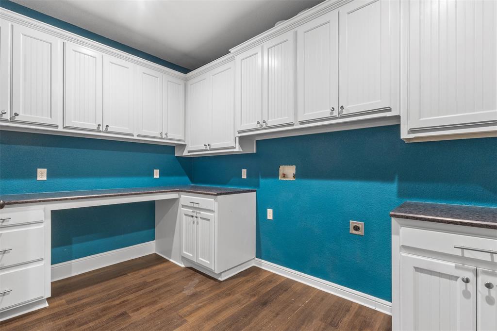 910 County Road 1111 Decatur, TX 76234 - Photo 26 of 40 Laundry area with dark wood-type flooring, washer hookup, electric dryer hookup, and cabinet space