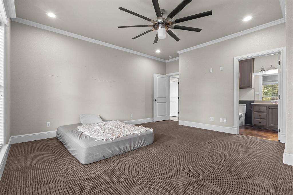 910 County Road 1111 Decatur, TX 76234 - Photo 27 of 40 Bedroom with crown molding, recessed lighting, a ceiling fan, ensuite bath, and dark carpet