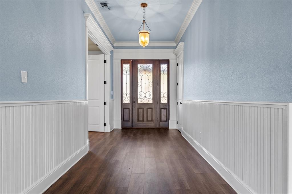 910 County Road 1111 Decatur, TX 76234 - Photo 4 of 40 Foyer with a textured wall, dark wood-style floors, and crown molding