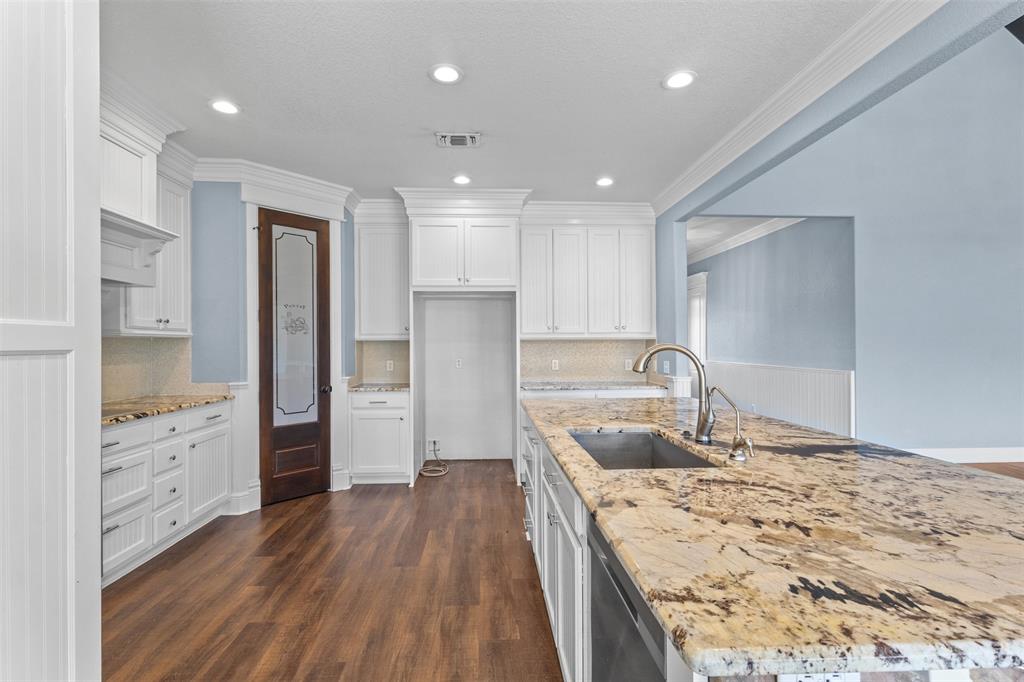910 County Road 1111 Decatur, TX 76234 - Photo 5 of 40 Kitchen featuring dark wood-style floors, light stone counters, white cabinetry, recessed lighting, and a kitchen island with sink