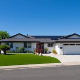 a front view of a house with a yard and trees