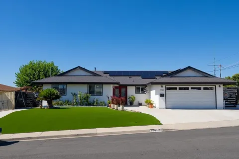 a front view of a house with a yard and trees