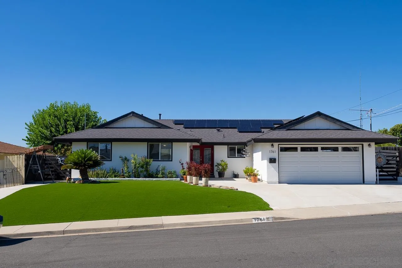 a front view of a house with a yard and trees