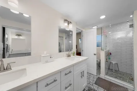 a bathroom with a double vanity sink mirror and shower