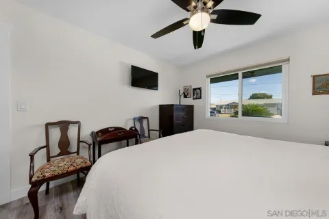 a bedroom with a bed a chandelier and a window