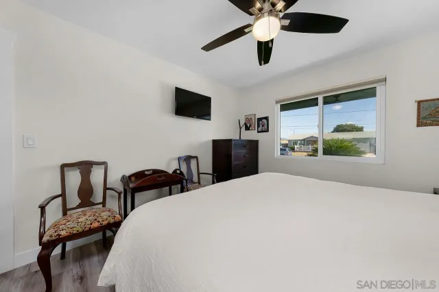 a bedroom with a bed a chandelier and a window