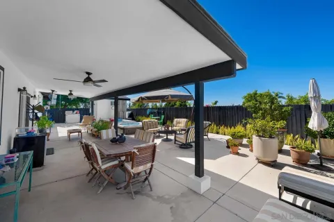 a view of a patio with chairs and potted plants