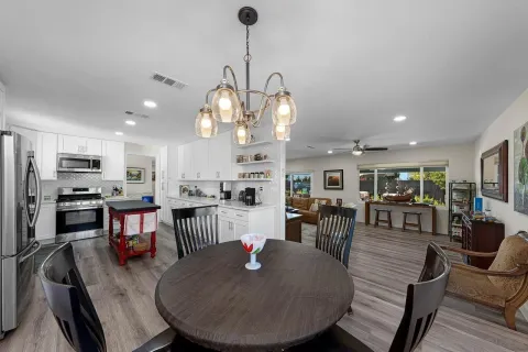 a living room with stainless steel appliances kitchen island furniture and wooden floor