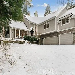 a front view of a house with a yard covered in snow