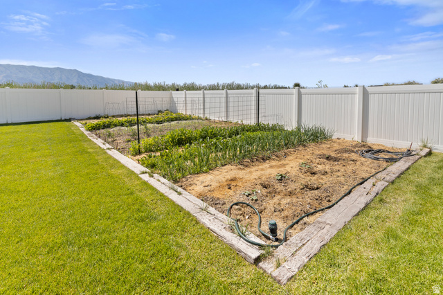 3111 South 1250 West Logan, UT 84321 - Photo 44 of 51 Expansive garden plot with wood-look borders, surrounded by a white privacy fence