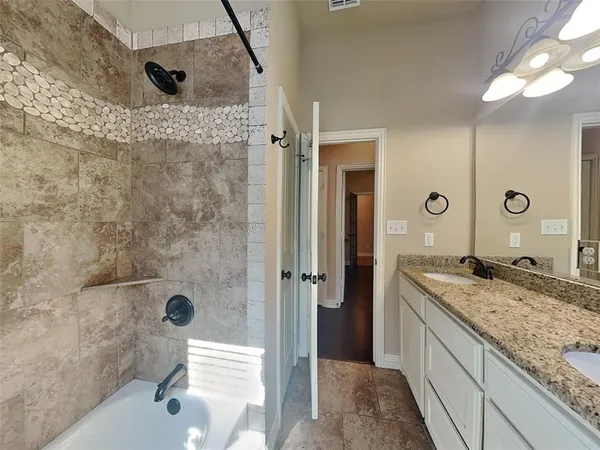 a bathroom with a granite countertop sink a mirror and shower