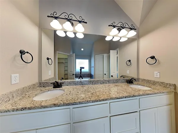 a bathroom with a granite countertop sink and a mirror