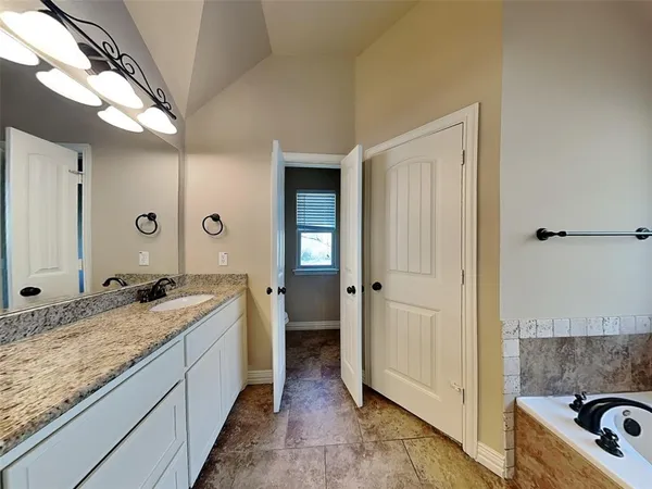 a spacious bathroom with a granite countertop sink and a mirror