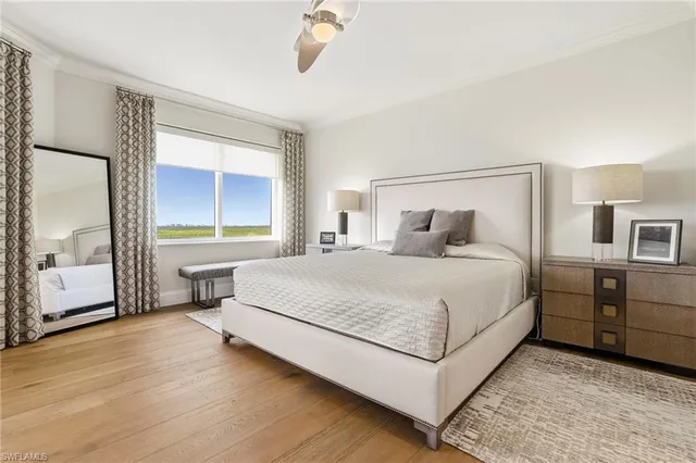 a bedroom with a large bed and a chandelier