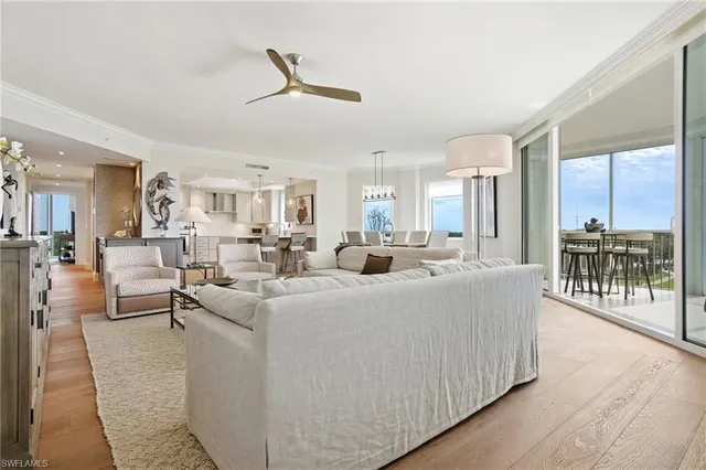 a living room with furniture a wooden floor and a chandelier
