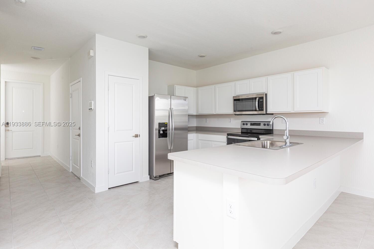1780 Southeast 9th Avenue Homestead, FL 33034 - Photo 3 of 20 a kitchen with a refrigerator a stove a microwave and cabinets