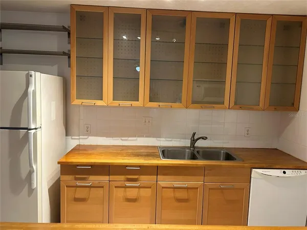 a kitchen with granite countertop cabinets and refrigerator